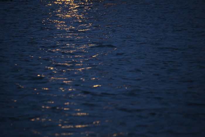 Reflections of yellow light on water in the night.