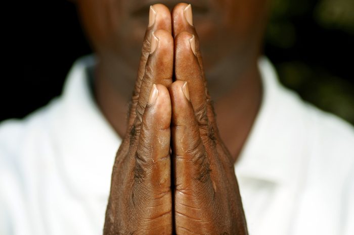 fingers of afro man in prayer