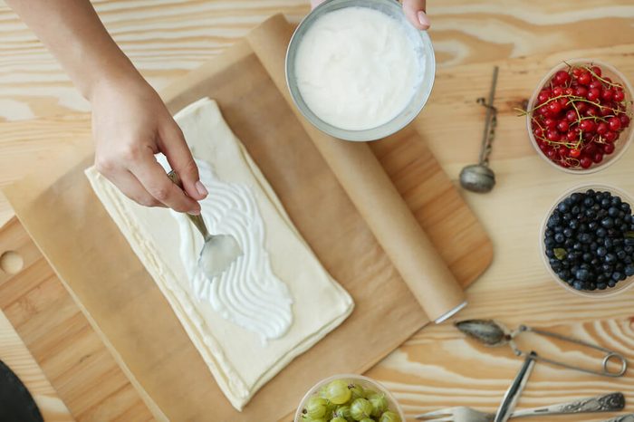 Woman making berry dessert, top view