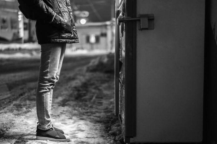 Woman standing in front of vending machine,Woman choosing drink at Night on road side with snowy ground,Japan vending machine in tokyo,High ISO image.