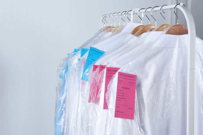 Rack of clean clothes hanging on hangers at dry-cleaning