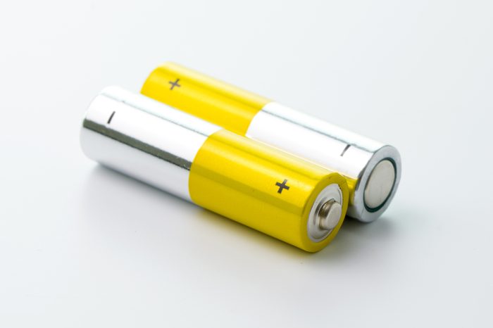 Two yellow AA size batteries isolated on white backgraound