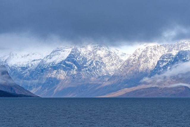 Dramatic Mountains Breaking Through the Coastal Clouds in Auyuittiq National Park on Baffin Island near Pangnirtung, Nunavut, Canada