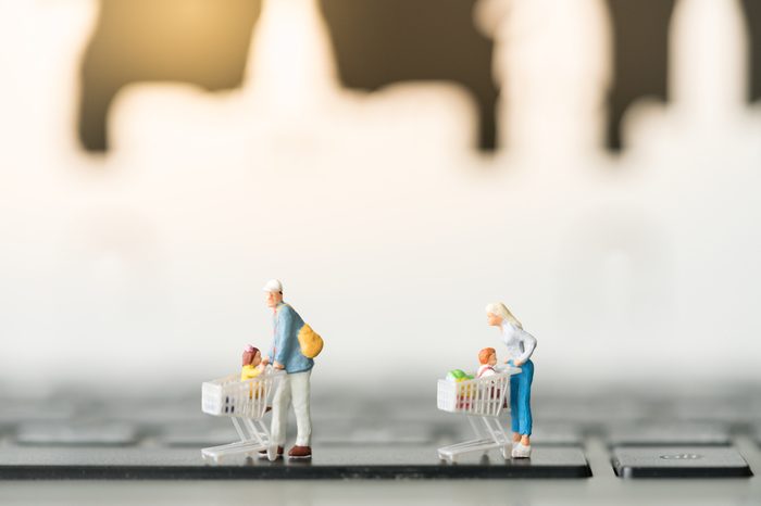 Miniature with shopping cart using as background business online concept.