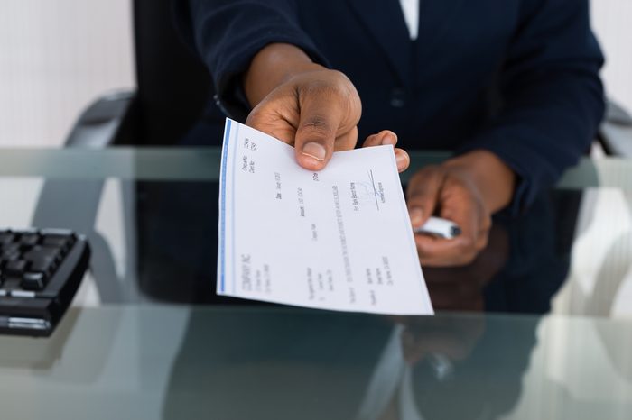 Close-up Photo Of Person's Hand Giving Cheque