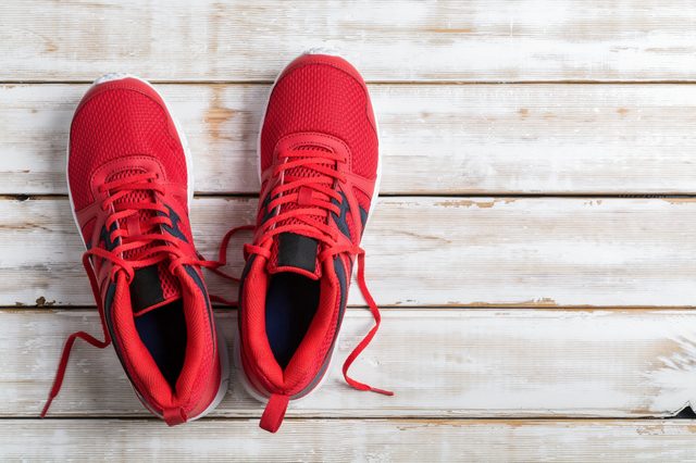 Red running shoe on white wood board