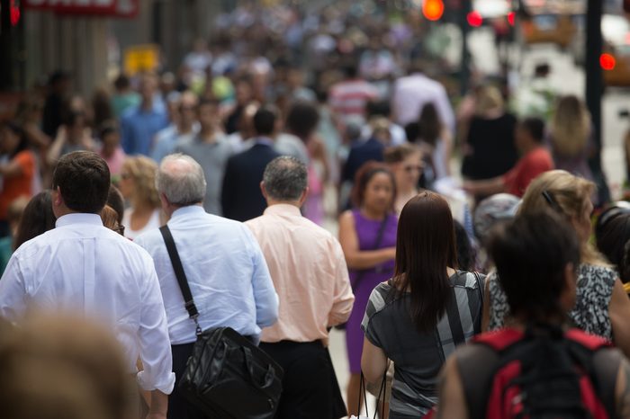 Crowd of people walking on street sidewalk in New York City