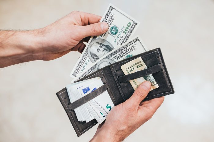 Man looks in the wallet. Cash. Wealthy man counting his money. Close up.