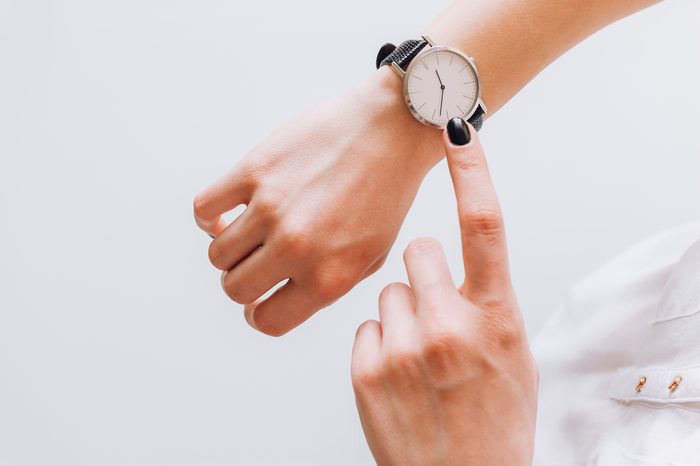 A young business woman is late on time, in a hurry she checks the deadline on her classic watch