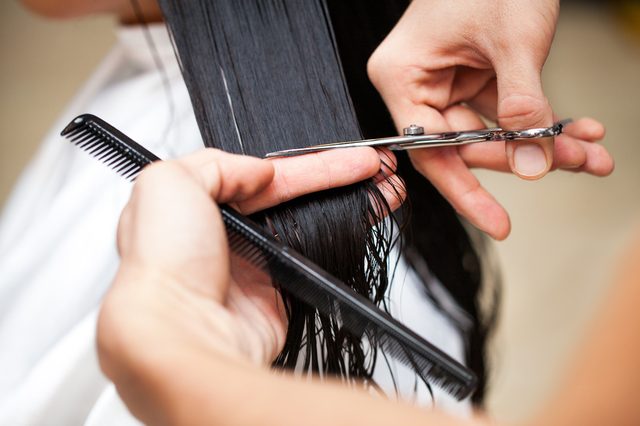 Hairdresser's hands cutting hair.