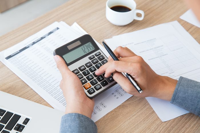 Man using calculator to count income and outcome