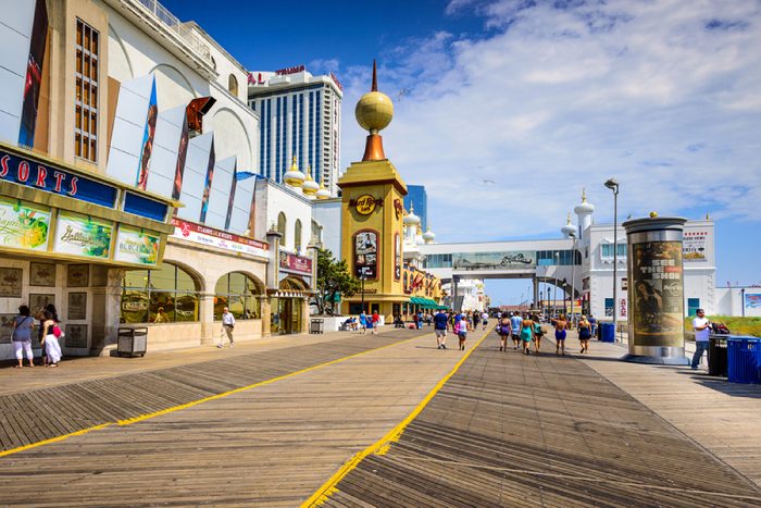 ATLANTIC CITY, NEW JERSEY - SEPTEMBER 9, 2012: Tourists walk on the boardwalk in Atlantic City.