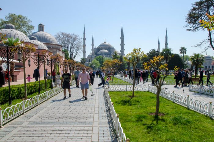 ISTANBUL, TURKEY - APRIL 30: Tourist walking near Blue mosque and Sultanahmet park on April 30th, 2018 Istanbul, Turkey. The biggest mosque in Istanbul of Sultan Ahmed (Ottoman Empire).