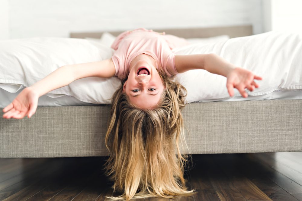 Cute little blonde girl in her pajamas on bedroom