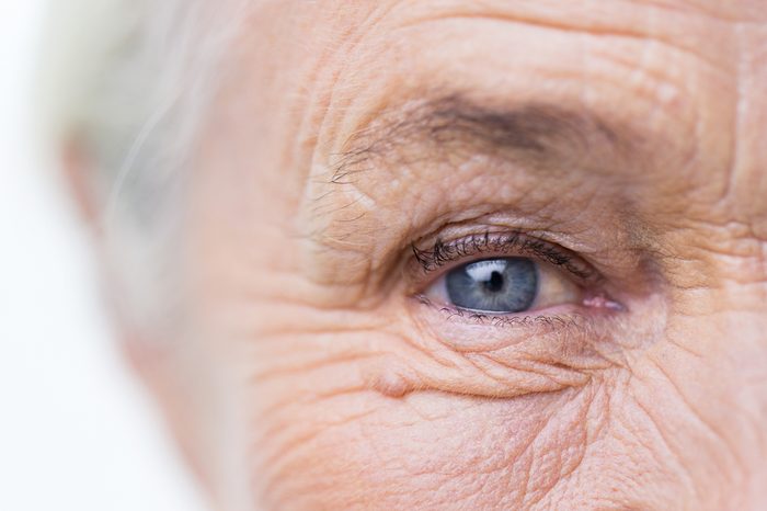 age, vision and old people concept - close up of senior woman face and eye