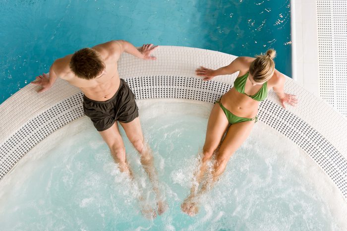 Top view - young couple relax in swimming pool sitting at bubble bath