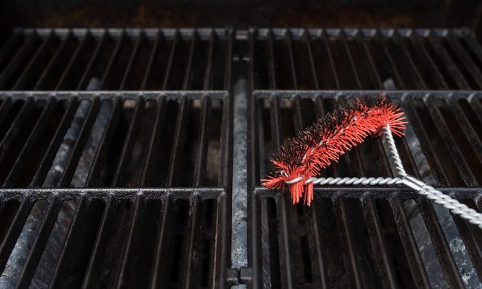 Close up focus of a scrubbing utensil used for cleaning a dirty grill. BBQ Grill Background Theme