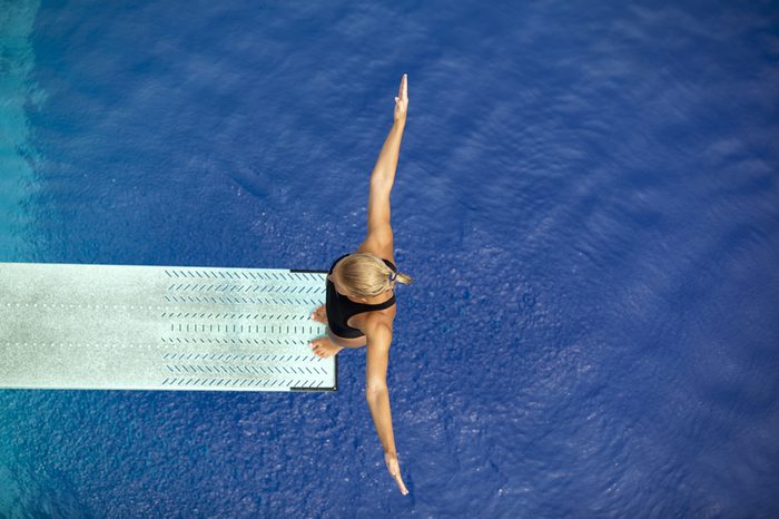 Girl standing on diving board, preparing to dive