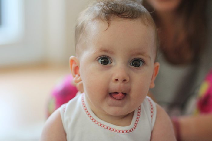 Little cute baby with tongue out.Weird funny face of a lovely cute baby
