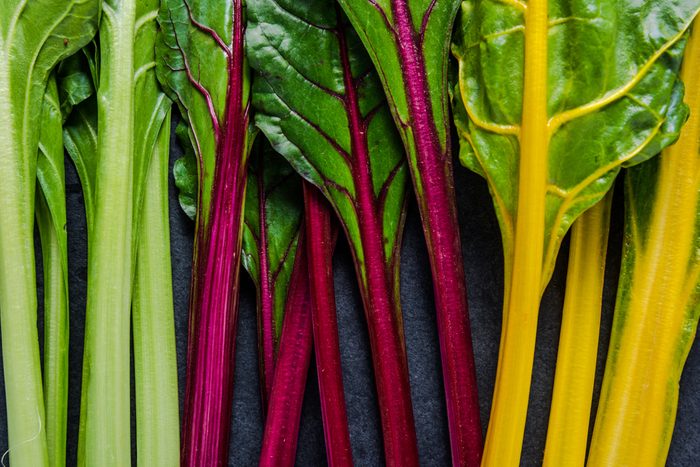 Swiss rainbow chard, vibrant vegetable. Flat lay, from above on dark slate.
