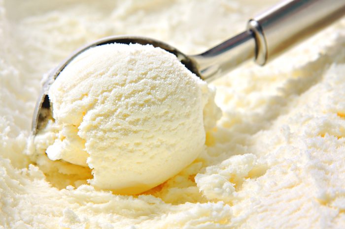 Vanilla ice cream scoop, scooped out of a container with a utensil