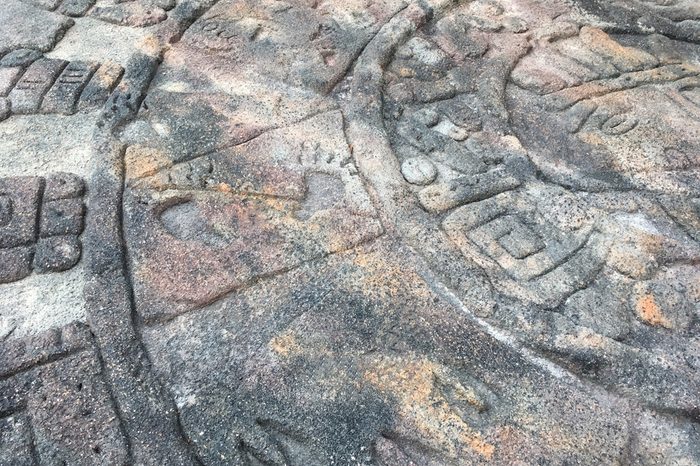 Ancient calendar signs carved on stone background close photo