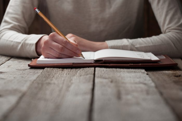 hand writes with a pen in a notebook