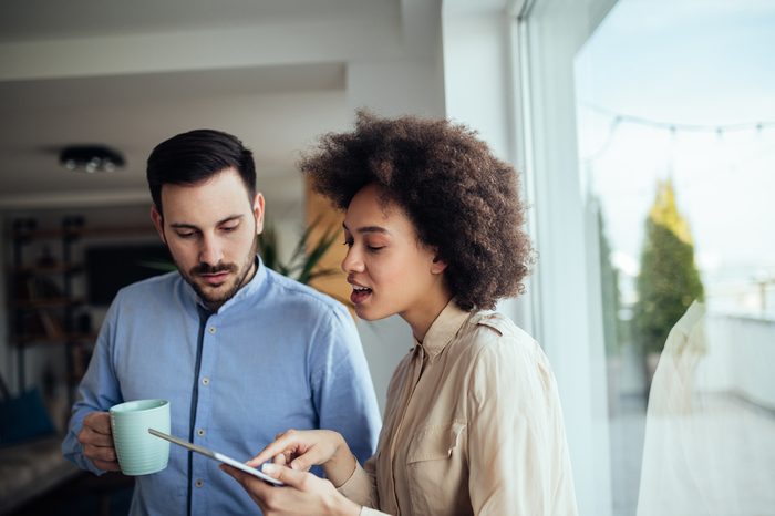 A young professional woman consulting her boss in a brightly lit office.