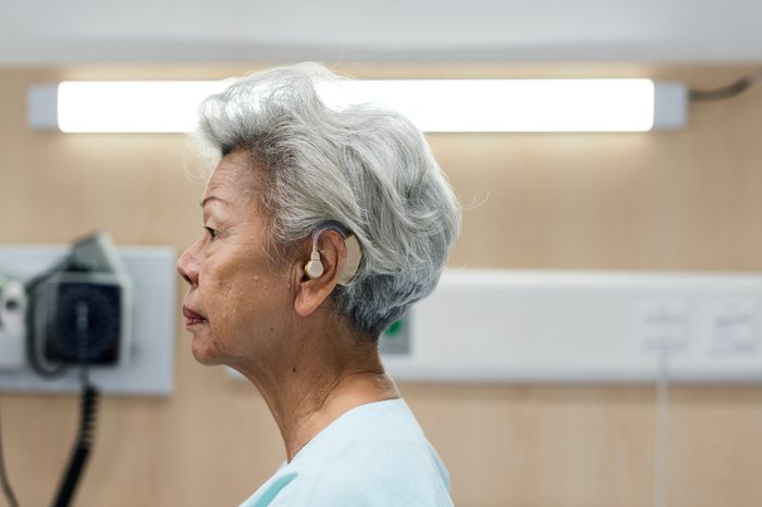 An elderly woman with hearing aid