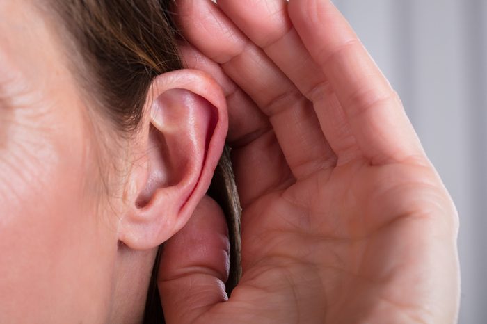 Woman Listening With Her Hand On An Ear