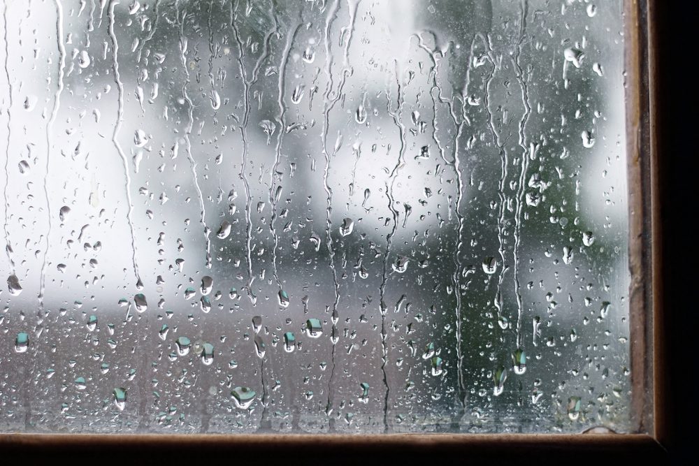 drops on the glass in rainy day. close up, the background