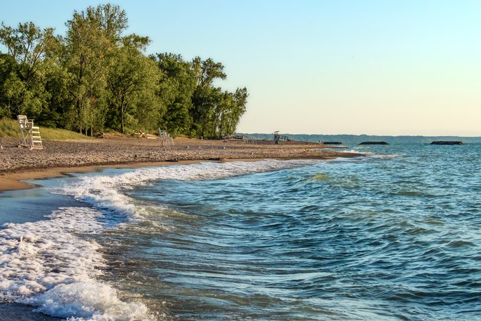 Deserted beach with lifeguard chairs and trees in background on Presque Isle on Lake Erie