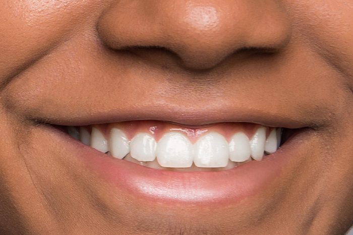 Joyful Afro American teen shows thumb up. Isolated on gray background. Studio portrait. Isolated on gray background.