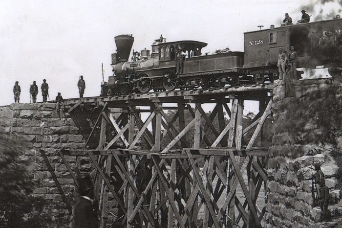 Firefly locomotive engine, built by Harris and Sons 1862, on a trestle of the Orange and Alexandria Railroad (US Military Railroad), Virginia, USA, built by soldiers, photograph by A.J. Russell, 1865.