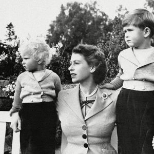 Queen Elizabeth II Prince Charles, four years old, is shown with his mother, Queen Elizabeth II, and sister, Princess Anne, on grounds of Balmoral Castle, Scotland, . Their interest is taken up with frolics of Royal household dogs