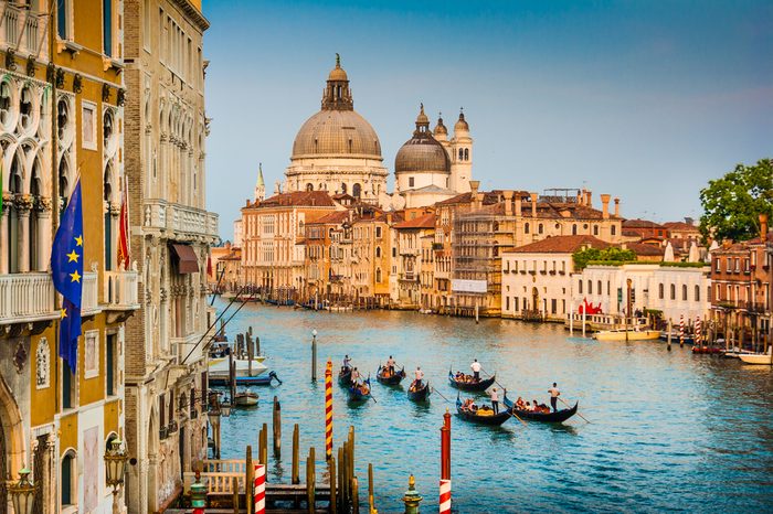 Beautiful view of Gondolas on famous Canal Grande with Basilica di Santa Maria della Salute at sunset in Venice, Italy