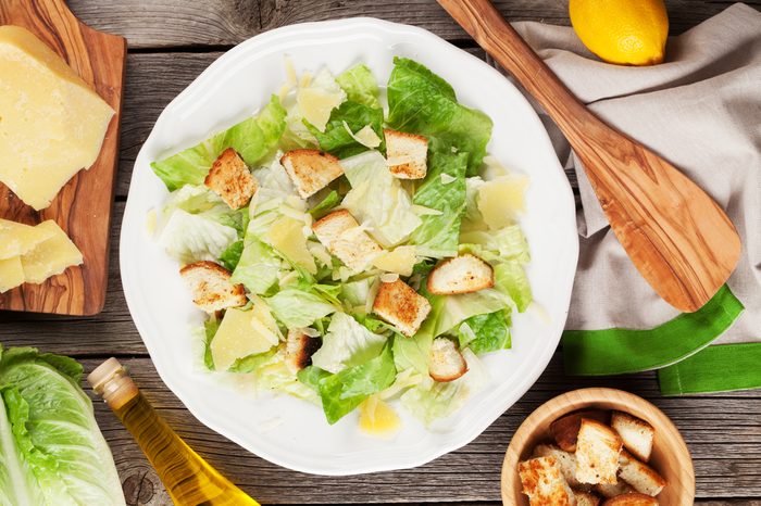 Fresh healthy caesar salad on wooden table. Top view