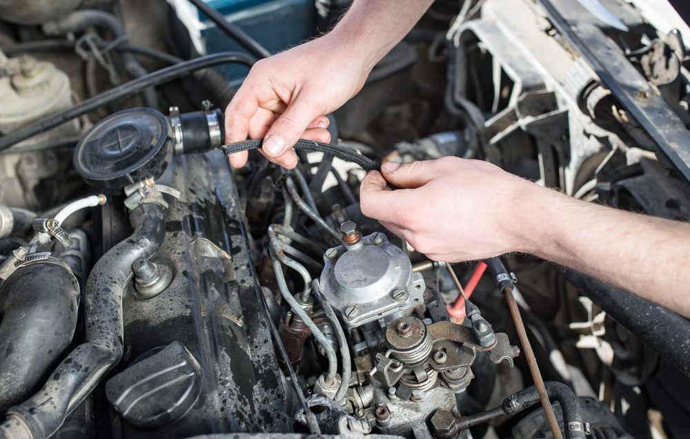 The master repairs under the hood of the car