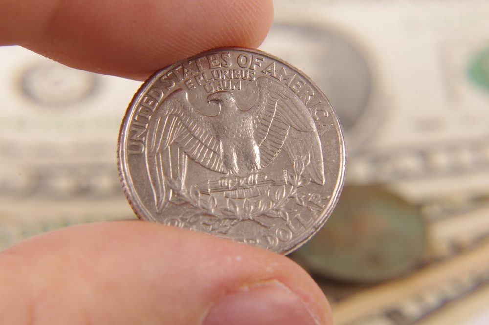 Male hand holding quarter dollar