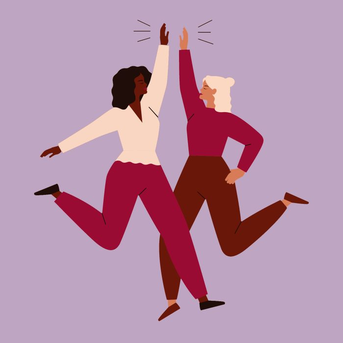 Two women high-five each other happily