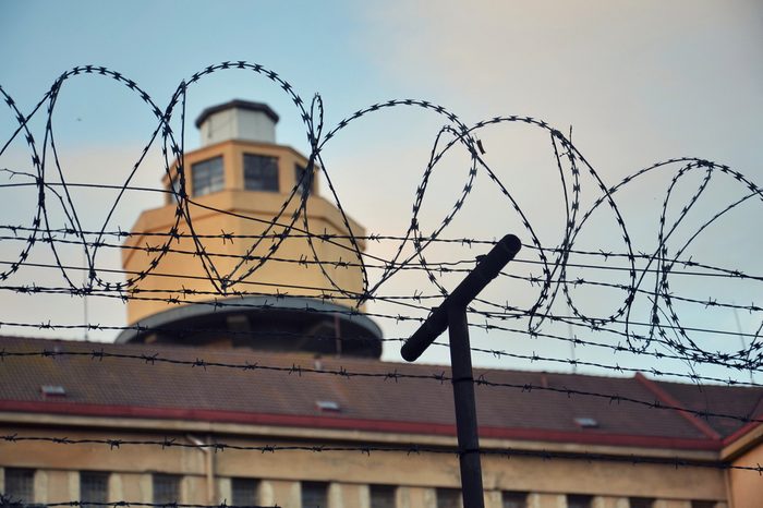 Barbed wire fence attached around prison walls