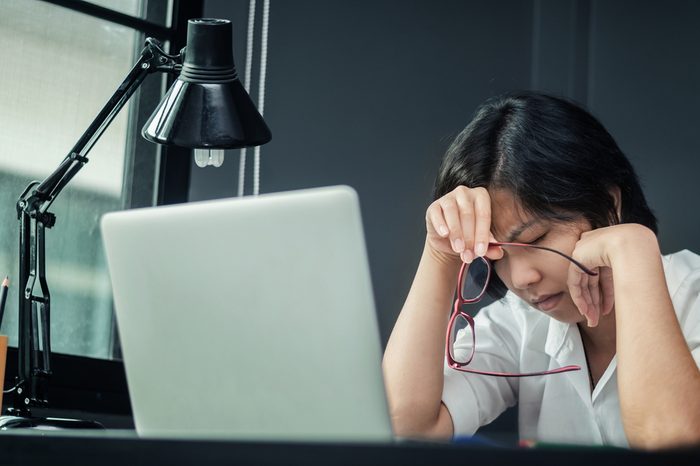 Close up of asian girl thinking about work. Glasses girl be ill. Business woman having headache and migraine. Exhausted and tired, stressed of businesswoman. 