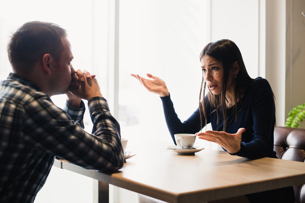 Young couple arguing in a cafe. Relationship problems.