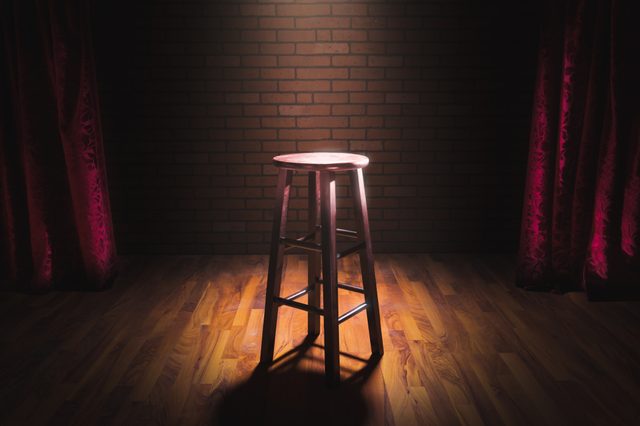 wooden stool on a stand up comedy stage with reflectors ray, high contrast image