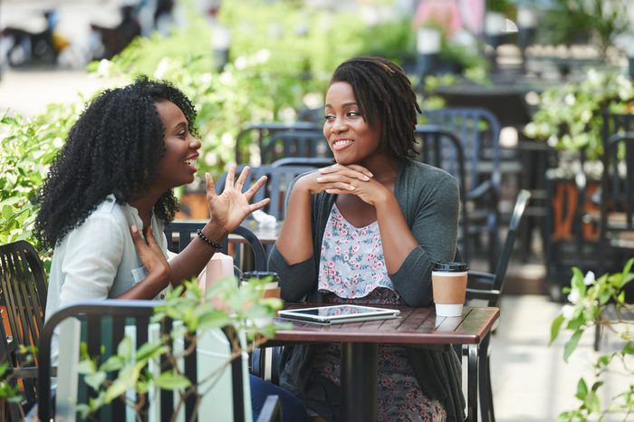 Pretty African-American woman telling story to her female friend