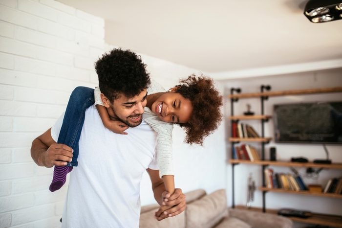 Cute african american kid playing with her dad.