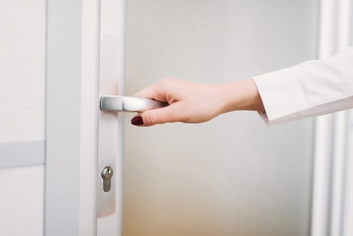 Coming to work, woman's hand opens the door