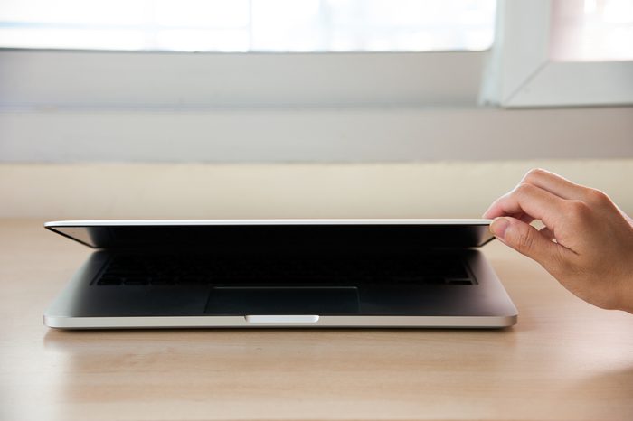 Hand open Laptop on wood table