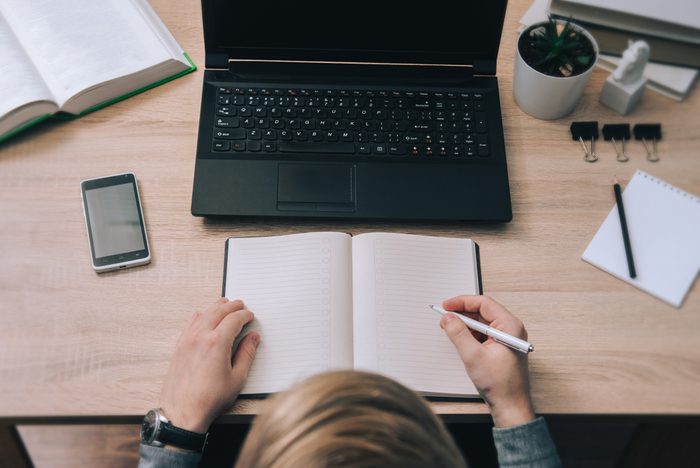 Guy writes in a diary some notes