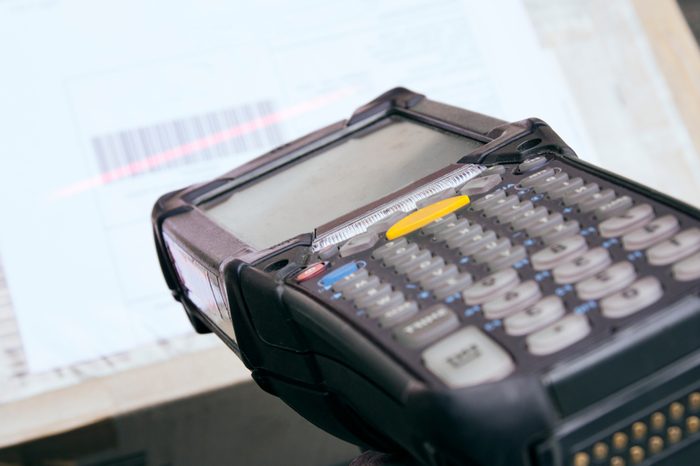 Close up barcode scanner with scanning on package box.